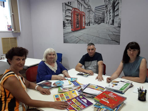 Maryna Tsehelska and meeting participants at a table with teaching materials