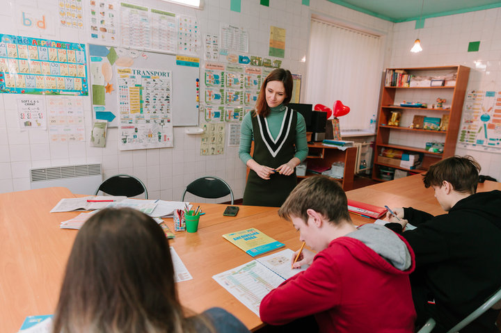 A teacher helps students work with learning maps in class